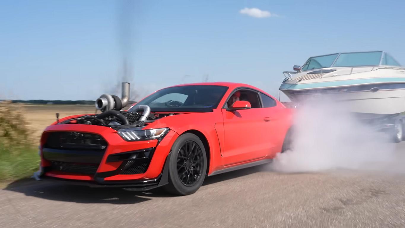 Mustang als Rolling-Coal mit Boot im Schlepptau